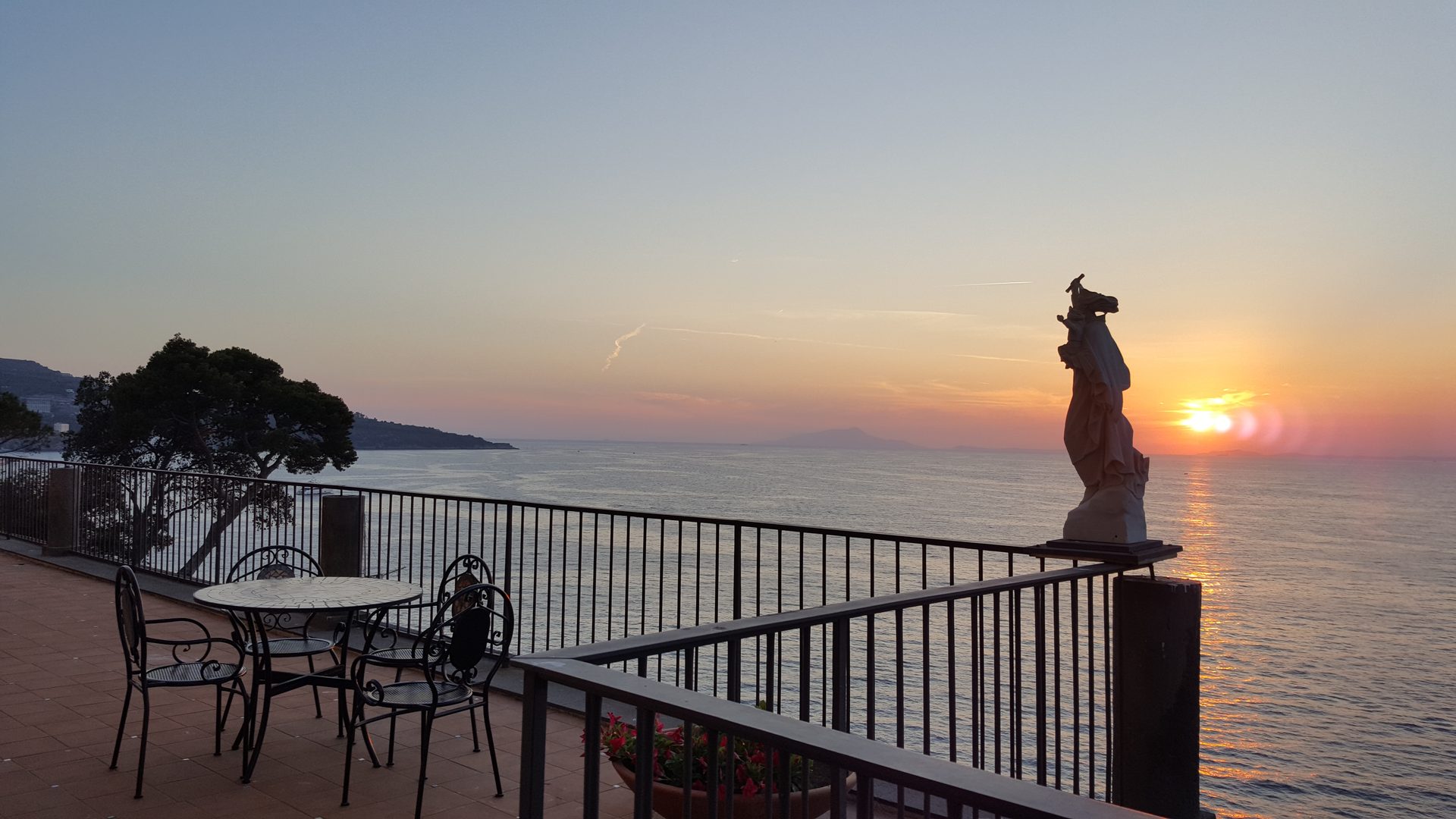 La terrazza panoramica al tramonto, con tavolino in ferro battuto affacciato sul golfo